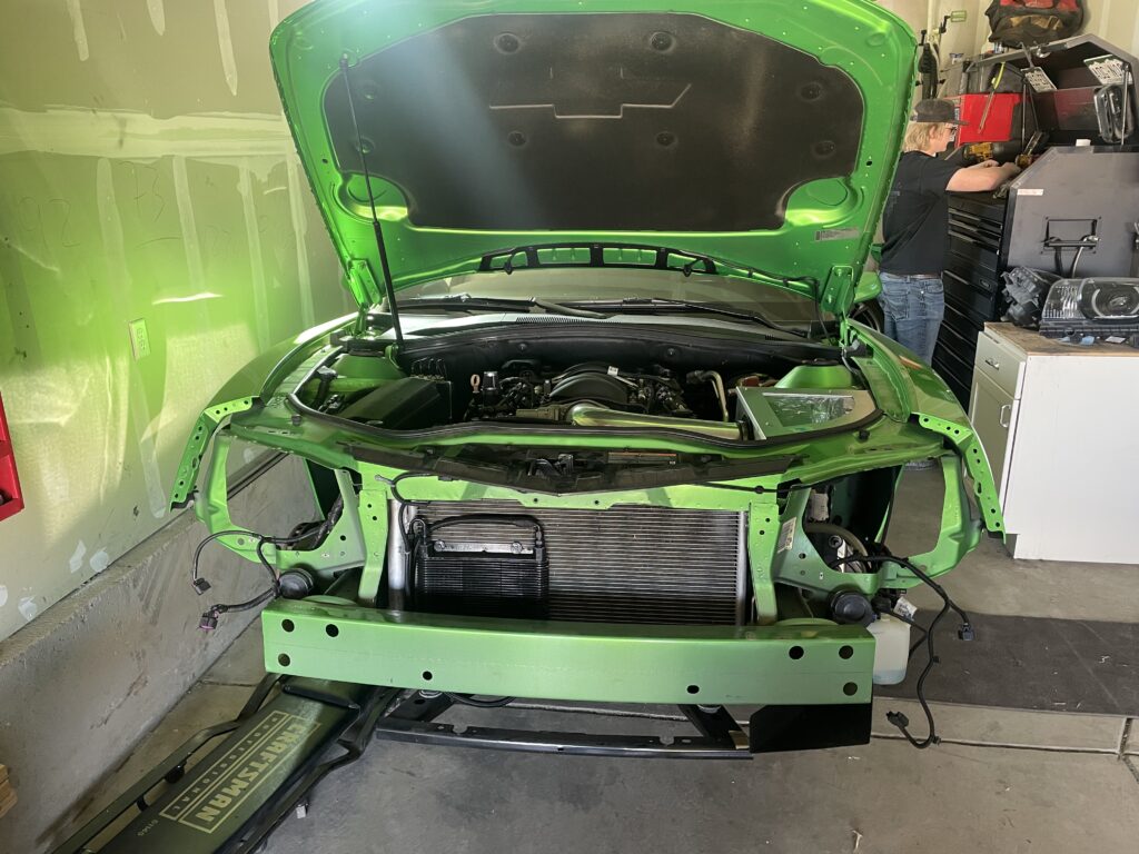 Front end stripped down on a green 2012 Camaro SS during the supercharger install